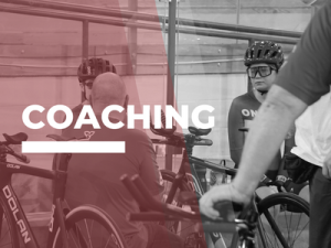 Group huddled around coach, focus on 1 rider looking intently