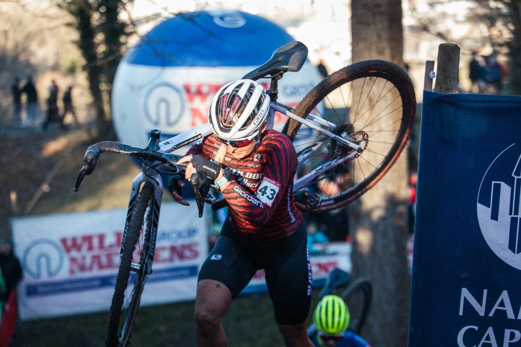 Siobhan Kelly racing through a cyclo-cross course with her bike on her shoulder