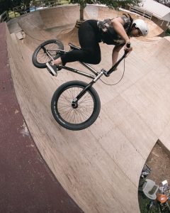 Woman riding a skate-park bowl on a bmx bicycle