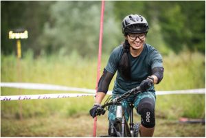 A Woman cyclist maneuvering her mountain bike through a field