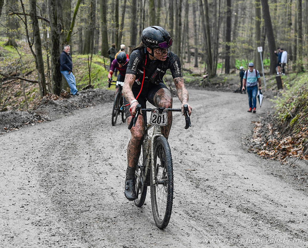 Devon Clarke Ascends a muddy gravel hill on her way to victory at Paris to Ancaster